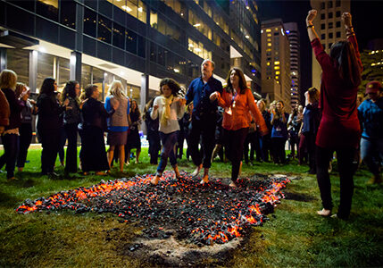 Three firewalkers proudly and confidently walk across burning embers in front of witnesses and supporters.